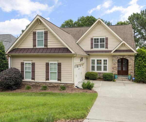 Well-maintained suburban home with neatly trimmed lawn, properly trimmed shrubs, and clean driveway.