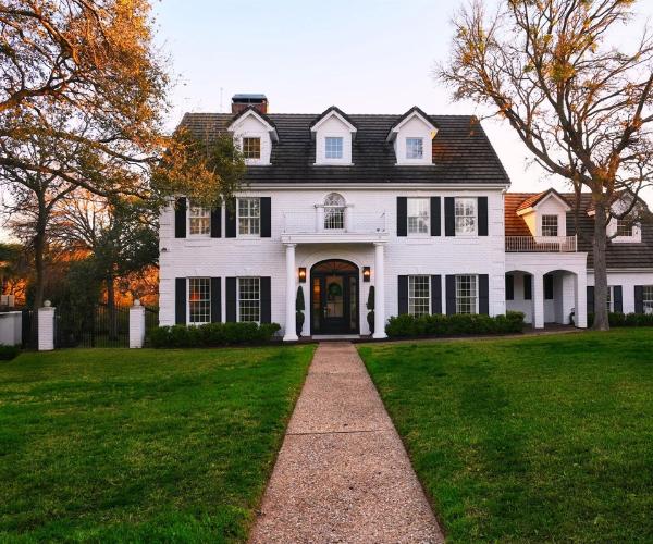 Large residential home with a clean front walkway, maintained lawn, and neatly shaped landscaping done by Lucky's Landscaping and Tree Service.