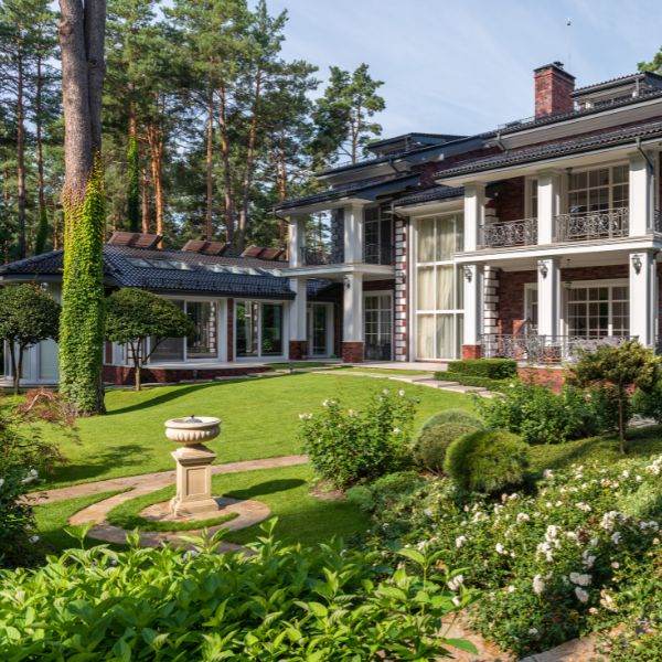Large home with well manicured lawn and properly pruned trees.